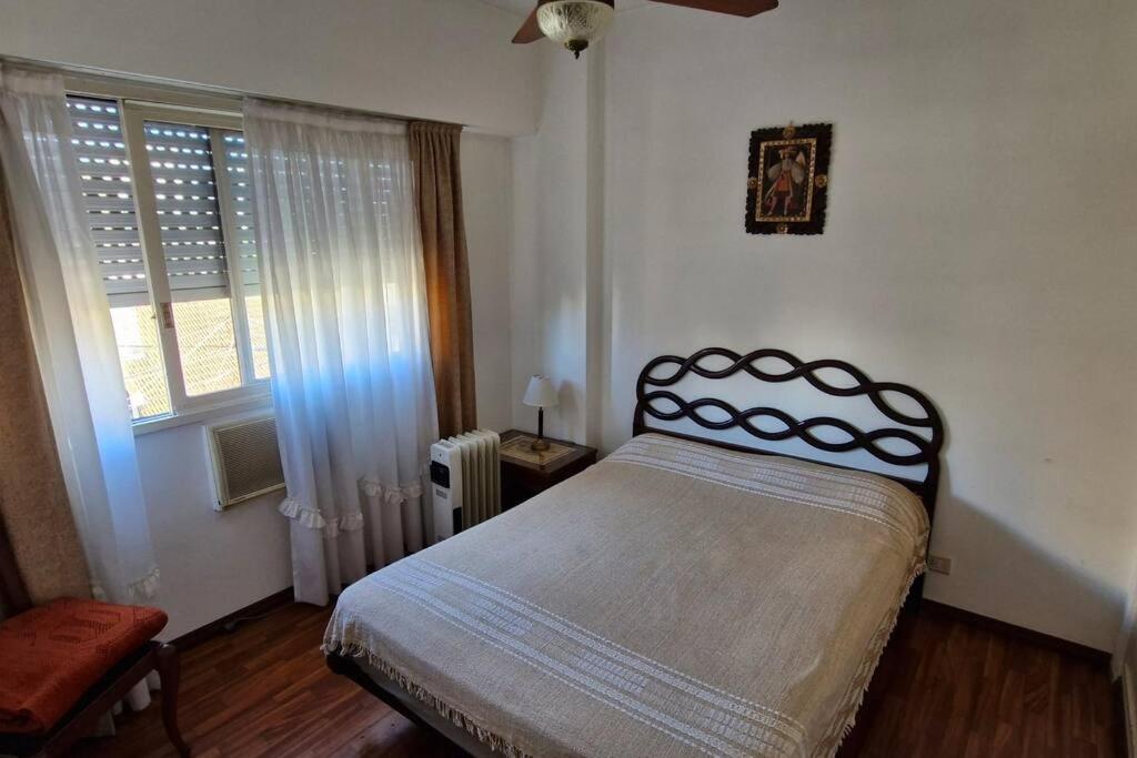 ein Schlafzimmer mit einem Bett und einem Fenster in der Unterkunft Departamento ideal corta estadía in Ramos Mejía