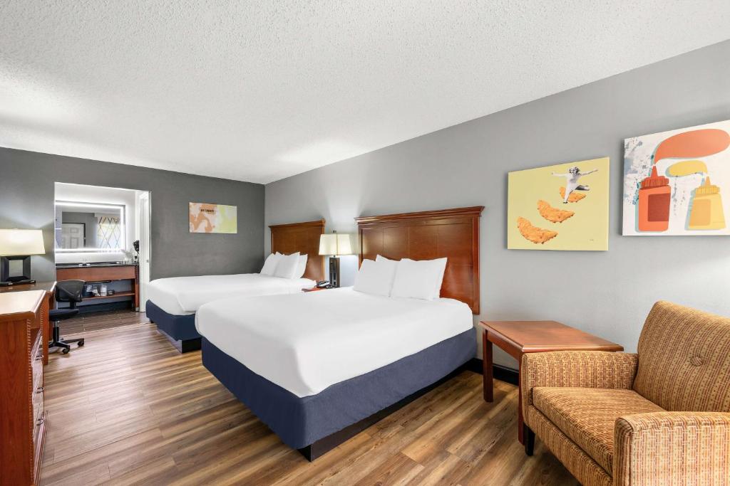 a hotel room with two beds and a couch at Best Western Corbin Inn in Corbin