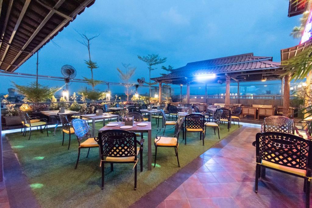 a restaurant with tables and chairs on a patio at night at Best Western La Vista Pathankot in Pathānkot