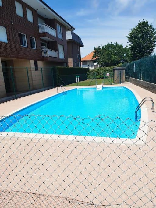a blue swimming pool with a fence around it at Atico en Ajo Cantabria in Ajo
