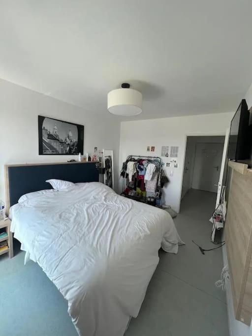 une chambre avec un grand lit blanc dans une pièce dans l'établissement Appartement - Batignolles Paris, à Paris