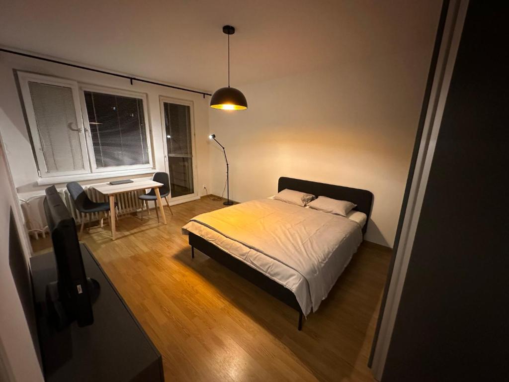 a bedroom with a bed and a table and a desk at Peaceful relaxation apartment - free parking in Bratislava