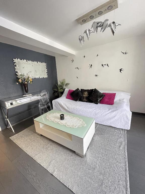 - une chambre avec un lit, une table et un piano dans l'établissement Beau 2 pièces à gare de Bondy et à seulement 10 min de Paris, à Bondy