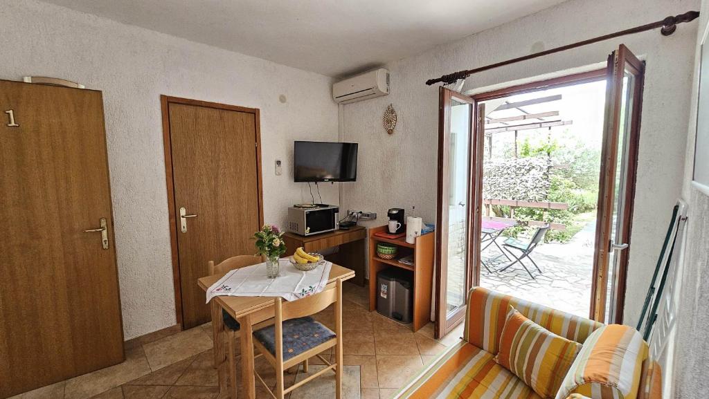 mały salon ze stołem i telewizorem w obiekcie Apartment Pinezici 5319b w mieście Pinezići