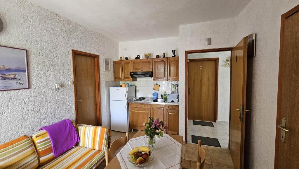 kuchnia ze stołem, na którym stoi miska z owocami w obiekcie Apartment Pinezici 5319b w mieście Pinezići