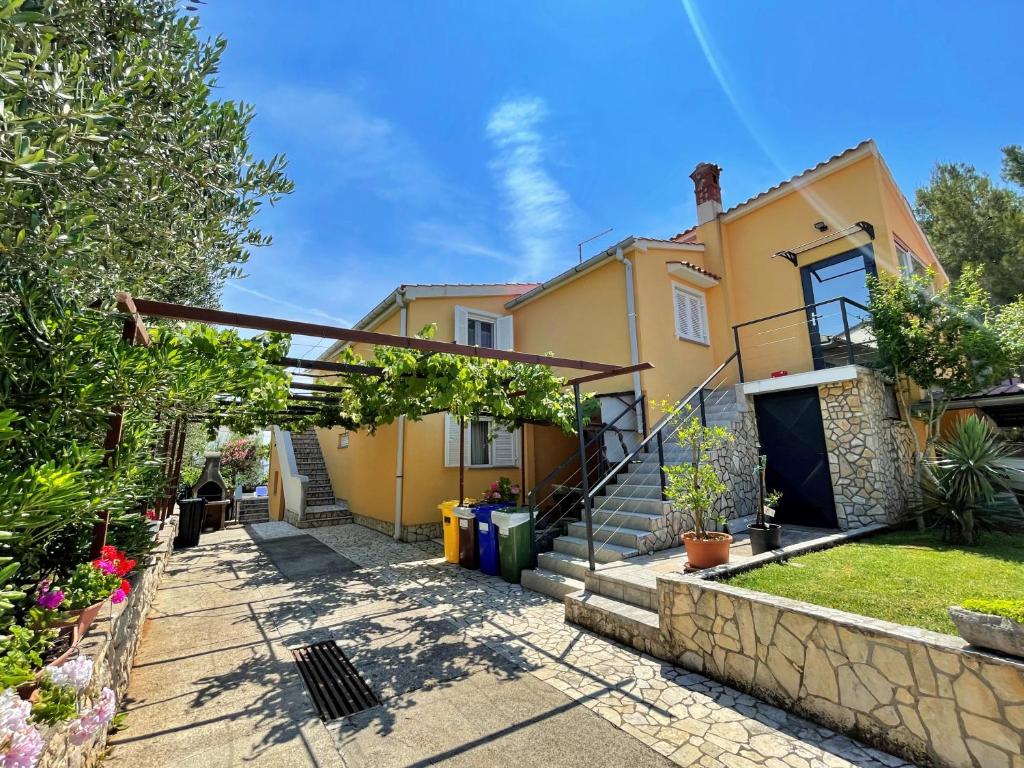 a yellow house with a walkway in front of it at Apartments with parking space Silo, Krk - 18757 in Šilo