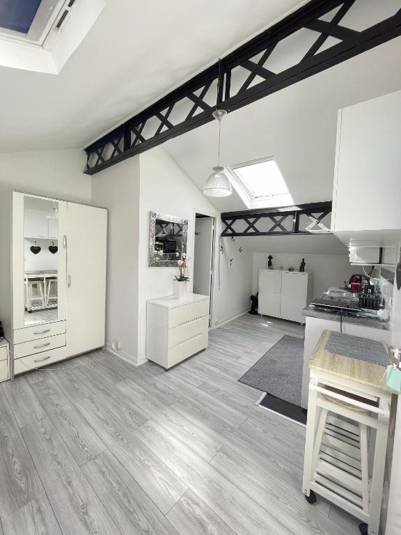 une grande cuisine avec des placards blancs et un comptoir dans l'établissement Beau studio lumineux à Bondy gare à seulement 10 min de Paris, à Bondy