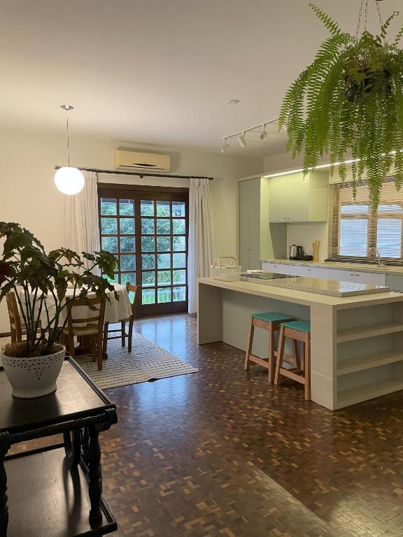 a kitchen and living room with a table and a dining room at Apartamento tropical no centro de Pomerode in Pomerode