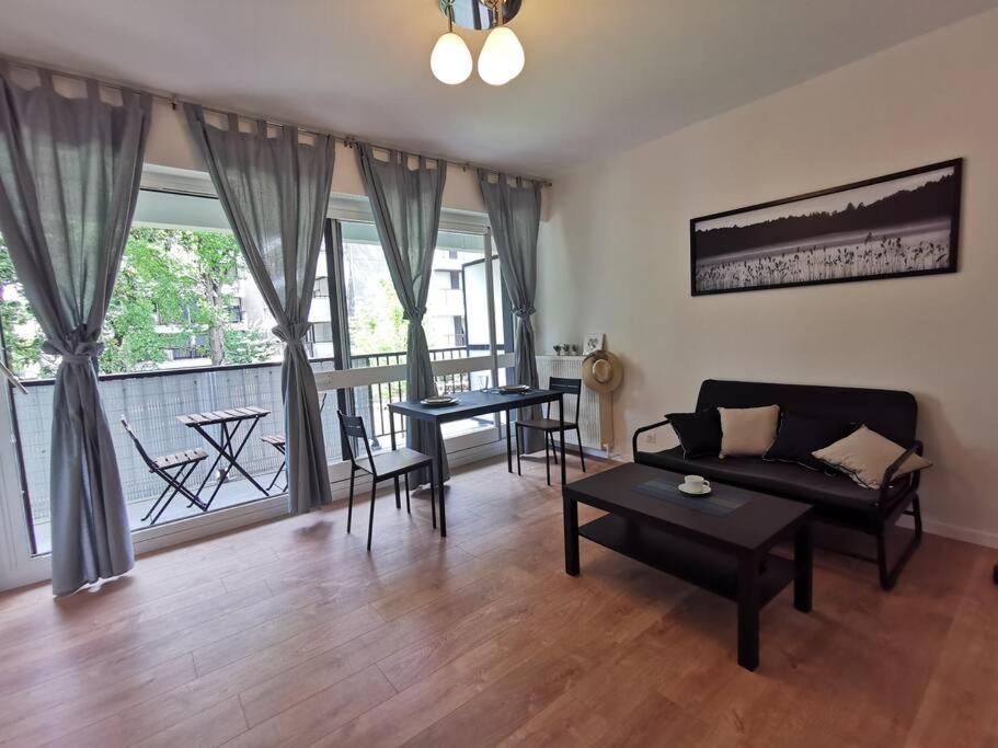 d'un salon avec un canapé et des tables, ainsi que d'un balcon. dans l'établissement Cosy Apartment at Mérignac-centre, à Mérignac