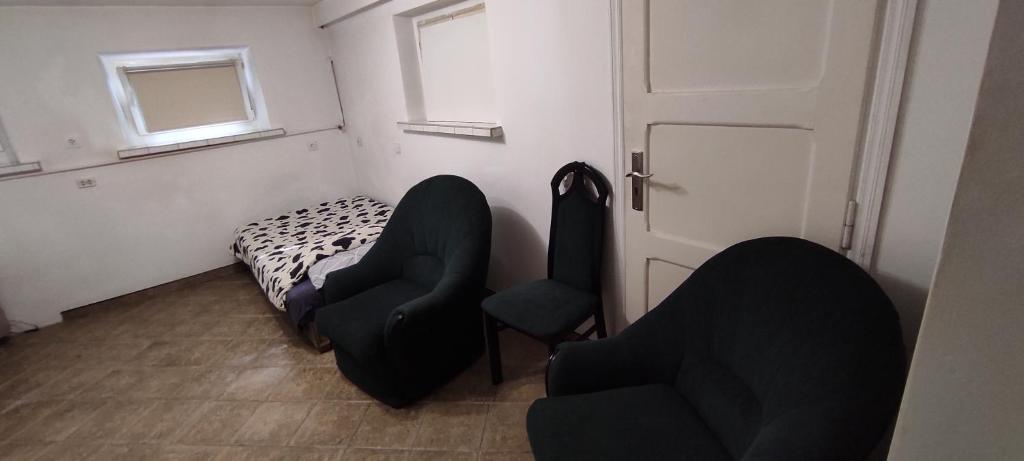 a room with two chairs and a bed and a door at Adam room piwnica in Wrocław