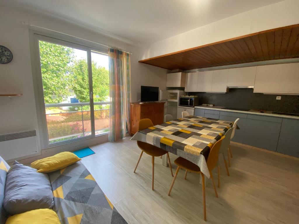 un salon avec une table et une cuisine dans l'établissement Appartement à 150m de la plage, centre-ville, parking privé, équipé tout confort - FR-1-22-297, à La Tranche-sur-Mer