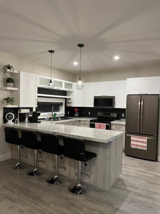 a kitchen with a large island with bar stools at Crystal's Place in Moncton