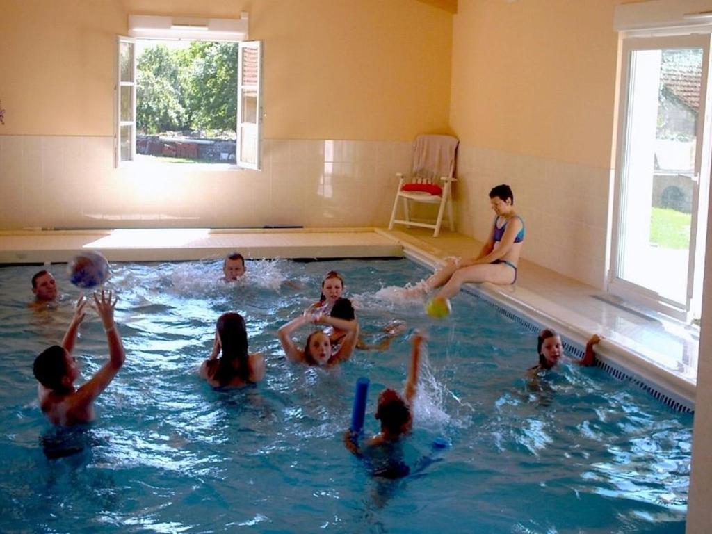eine Gruppe von Kindern, die im Pool spielen in der Unterkunft Maison avec Piscine Privée Chauffée, Cheminée et Activités à Goncourt - FR-1-611-106 in Goncourt