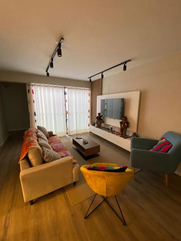 a living room with two couches and a mirror at DEPARTAMENTO KILLA HUATANA in Cusco