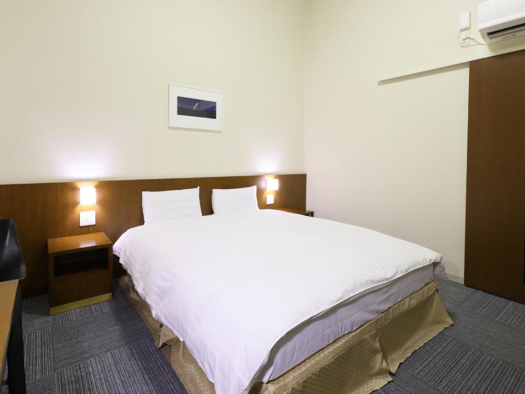 a large white bed in a hotel room at Dormy Inn Kanazawa Natural Hot Spring in Kanazawa