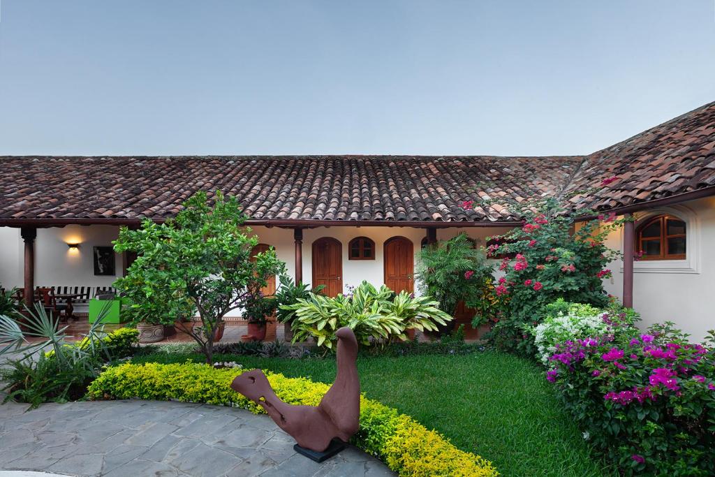 a garden with a statue of a duck in front of a house at Hotel Boutique Adela in Granada