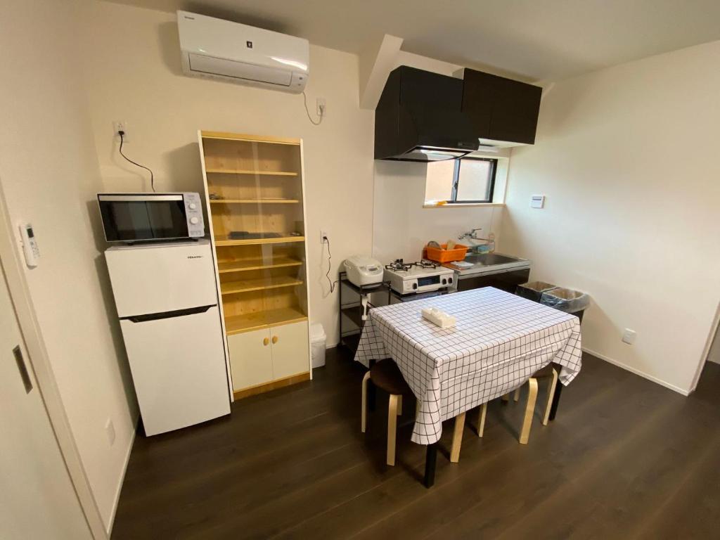una piccola cucina con tavolo e frigorifero bianco di 高島市一棟貸切 Biwa Lake琵琶湖 徒歩0分 大人数でご利用だとお得連泊がお得BBQ自転車無料利用可ペット可 a Takashima