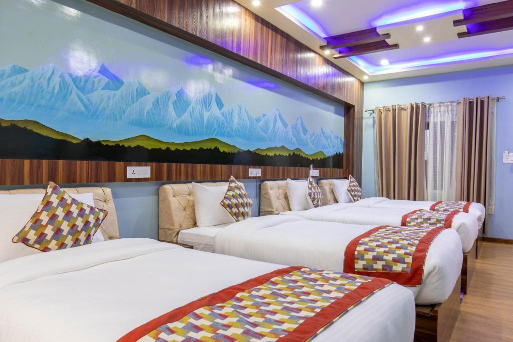 una camera d'albergo con tre letti e un grande murale di Siddhartha Hotel Grand City a Birtamod