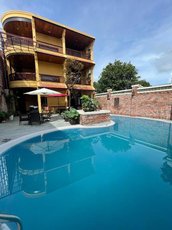 a large swimming pool in front of a building at Maison Duyên in Hue