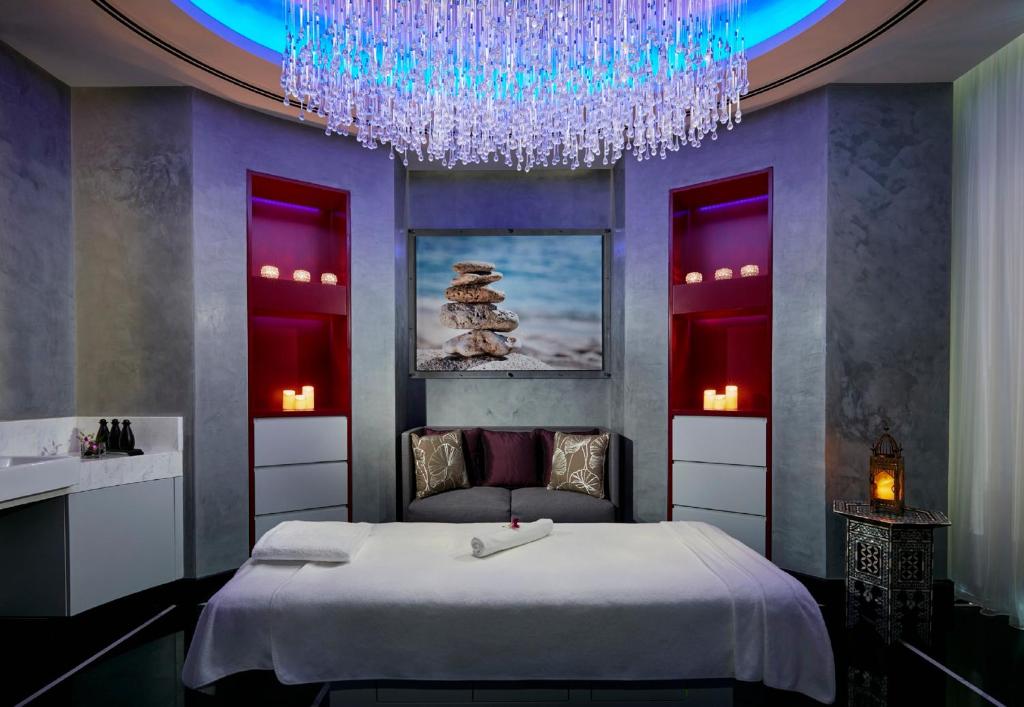 sypialnia z dużym łóżkiem i żyrandolem w obiekcie InterContinental Hotels Doha Residences w mieście Doha