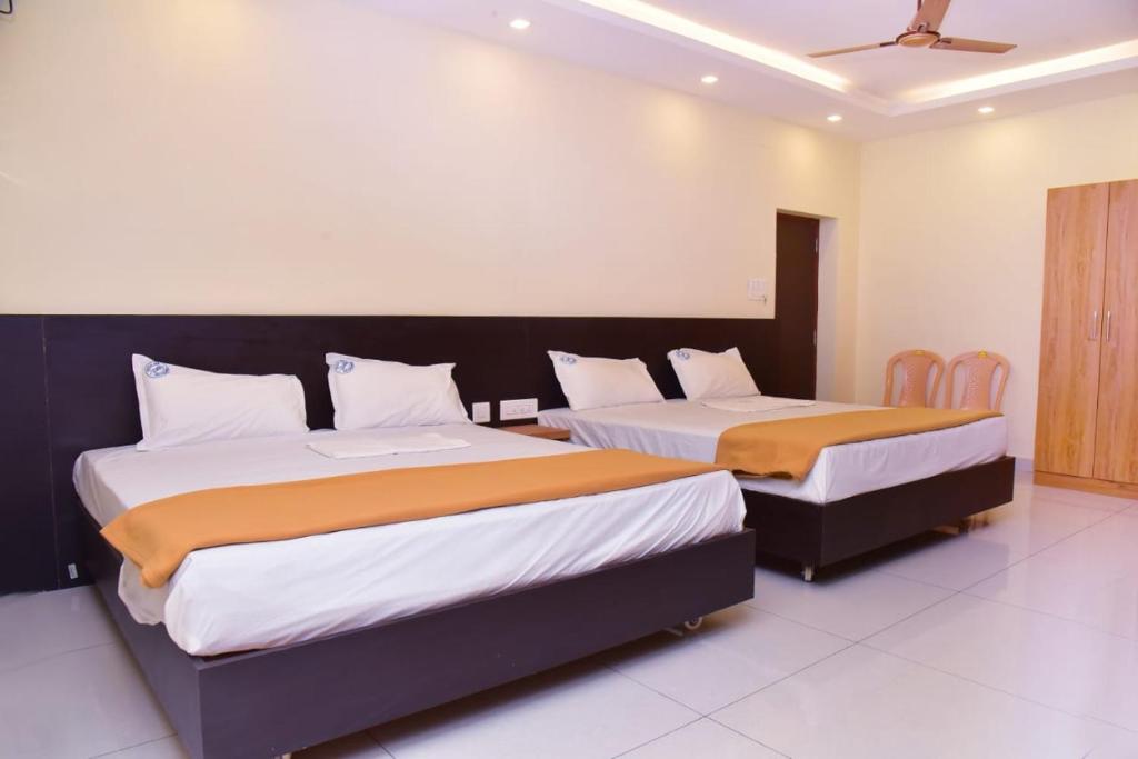 zwei Betten in einem Zimmer mit zwei Betten sidx sidx sidx sidx in der Unterkunft Hotel Devis Velankanni in Velankanni