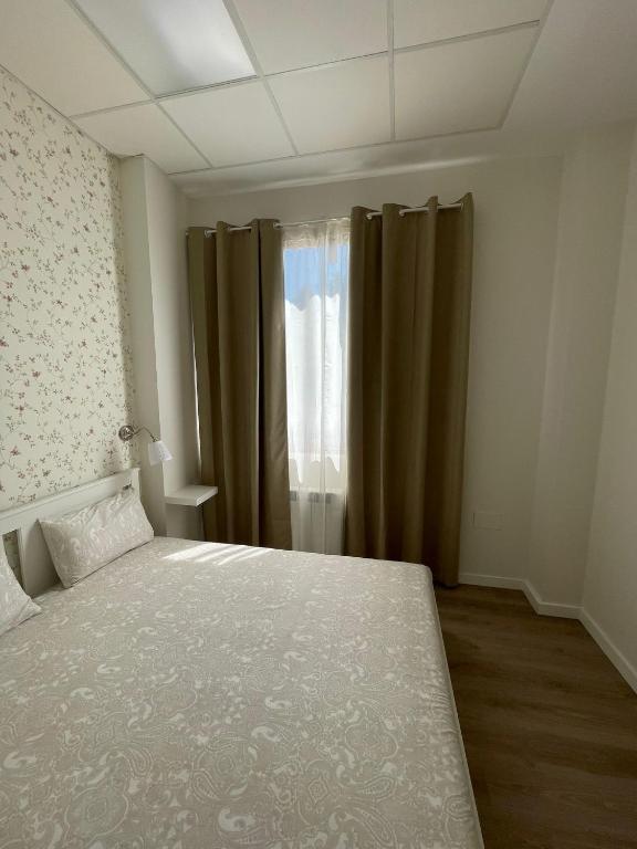 a bedroom with a bed and a window with curtains at Los cañones in Liérganes