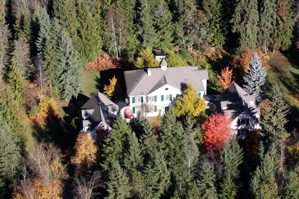 an aerial view of a large house in the forest at The Inn at the Ninth Hole Bed & Breakfast in Salmon Arm