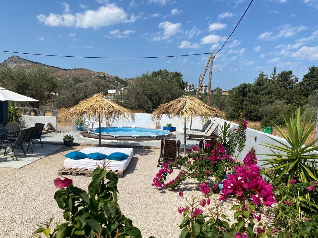 a patio with chairs and flowers and a pool at EnjoyRhodes Villa near Faliraki in Kalithies