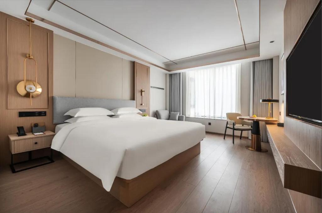Postel nebo postele na pokoji v ubytování Poltton Grand Century Hotel
