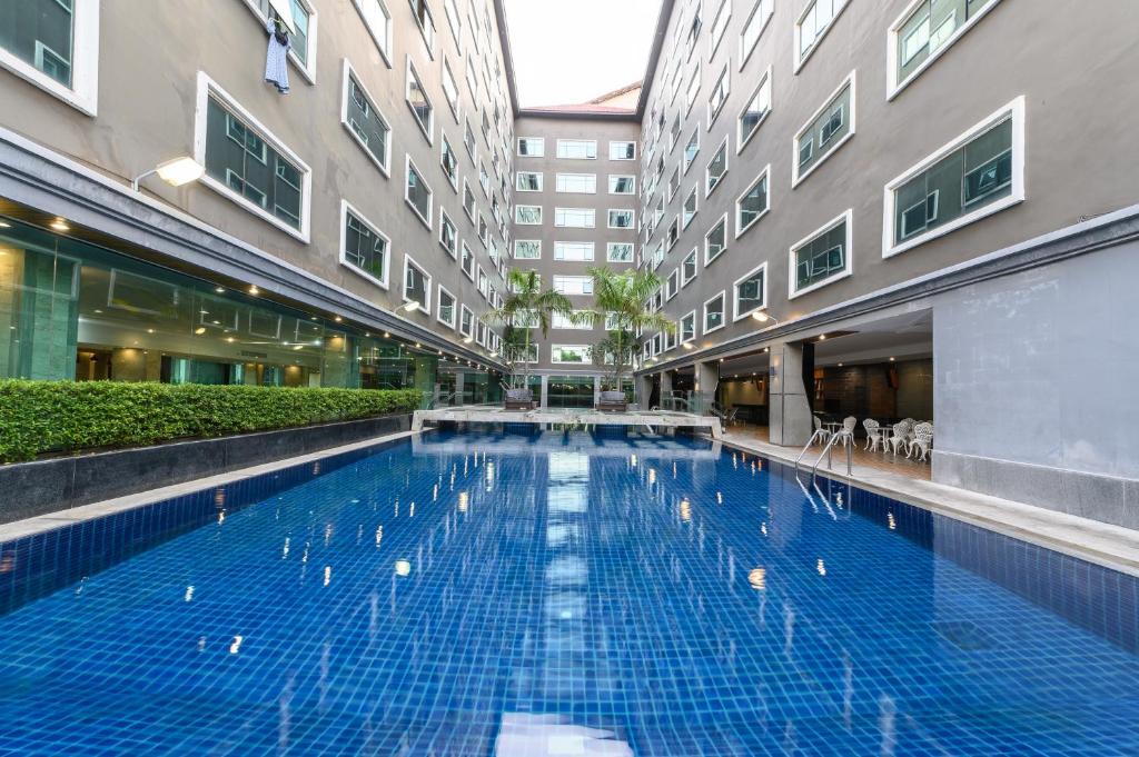 a large swimming pool in the middle of a building at โรงแรม อีส จอมเทียน บี in Jomtien Beach