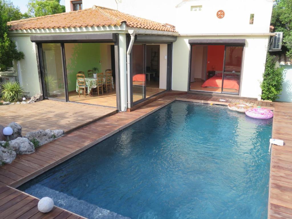 une piscine avec une terrasse et une maison dans l'établissement Charmante villa avec piscine tout près de l'étang., à Sète