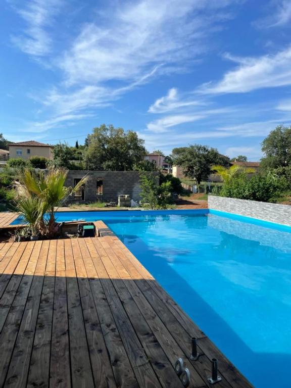 - une piscine avec une terrasse en bois et de l'eau bleue dans l'établissement studio au calme avec piscine, à Fréjus
