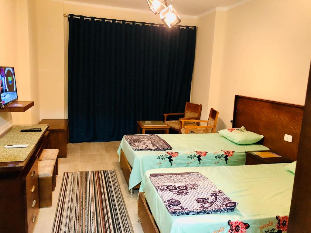 a hotel room with two beds and a television at قريه اكوا فيو الساحل الشمالى in El Alamein