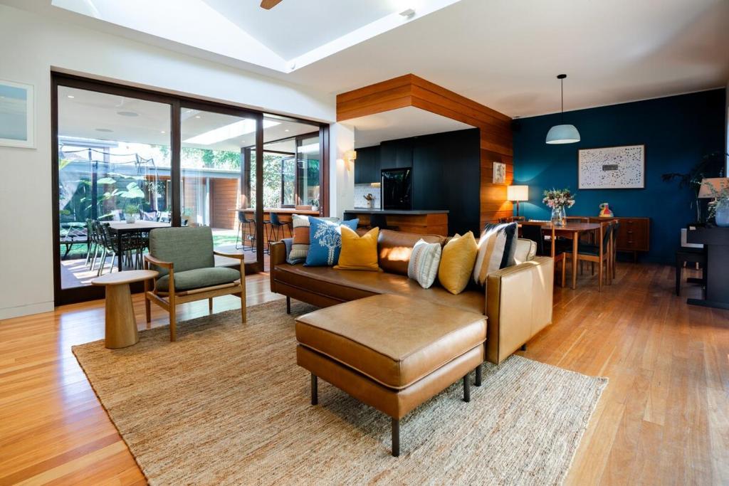 un soggiorno con un divano e un tavolo di Villa Catherine - 3BR Lilyfield a Sydney