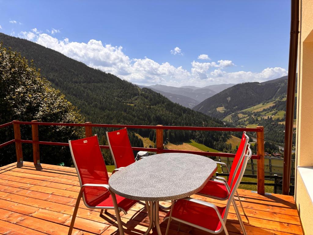 a table and four chairs on a deck with a view at Frankenberg Ferienwohnung in Aschbach