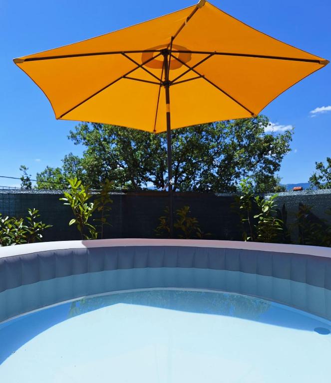 a large yellow umbrella sitting on top of a pool at Apartment Tanya with jacuzzi in Rijeka