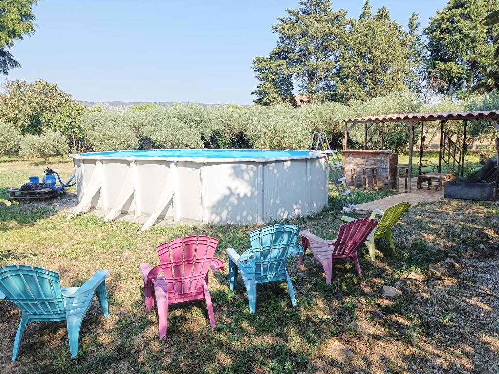 - un groupe de chaises dans une cour avec piscine dans l'établissement Véritable maison de campagne nouvellement rénovée au pied du Lubéron, à Cheval-Blanc