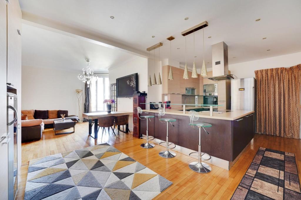 une cuisine et un salon avec un comptoir dans l'établissement Joli 90m2 - 2 ch proche Champs-Elysees, climatise, à Neuilly-sur-Seine