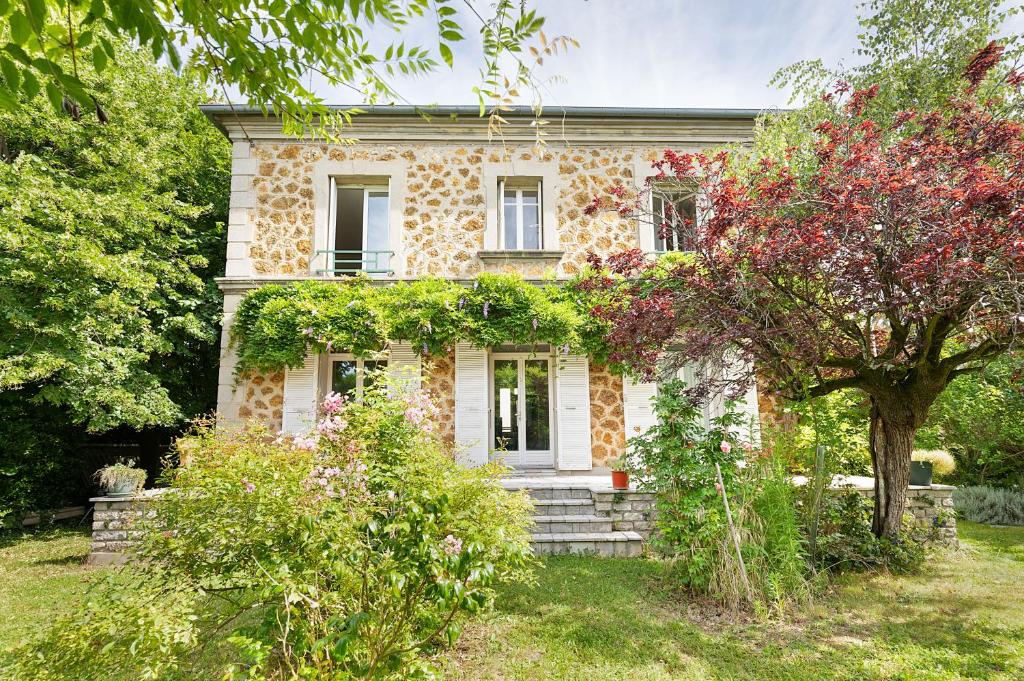 une vieille maison en pierre avec un arbre dans la cour dans l'établissement Cozy house with garage & large garden, PARIS Center 30min RER A, Orly airport, à Limeil-Brévannes