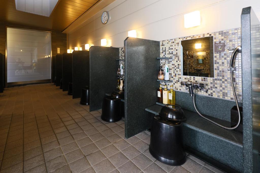 a row of stalls in a public restroom at Dormy Inn Kanazawa Natural Hot Spring in Kanazawa