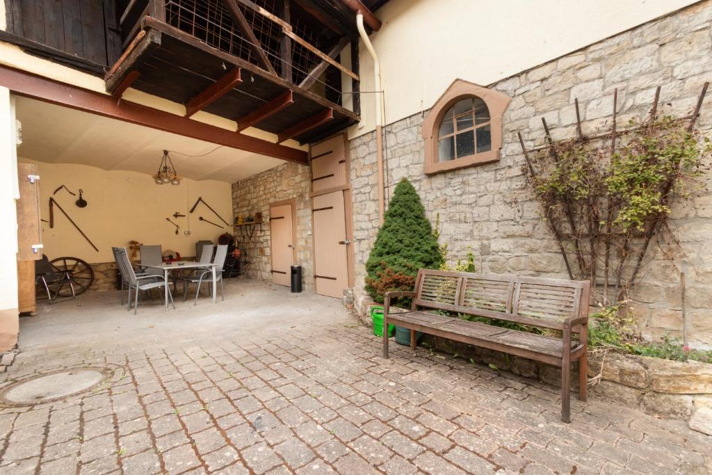 a patio with a wooden bench in front of a building at Wohnung für 8 Personen in ehemaligem Weingut mit 4 Schlafzimmern in Rommersheim