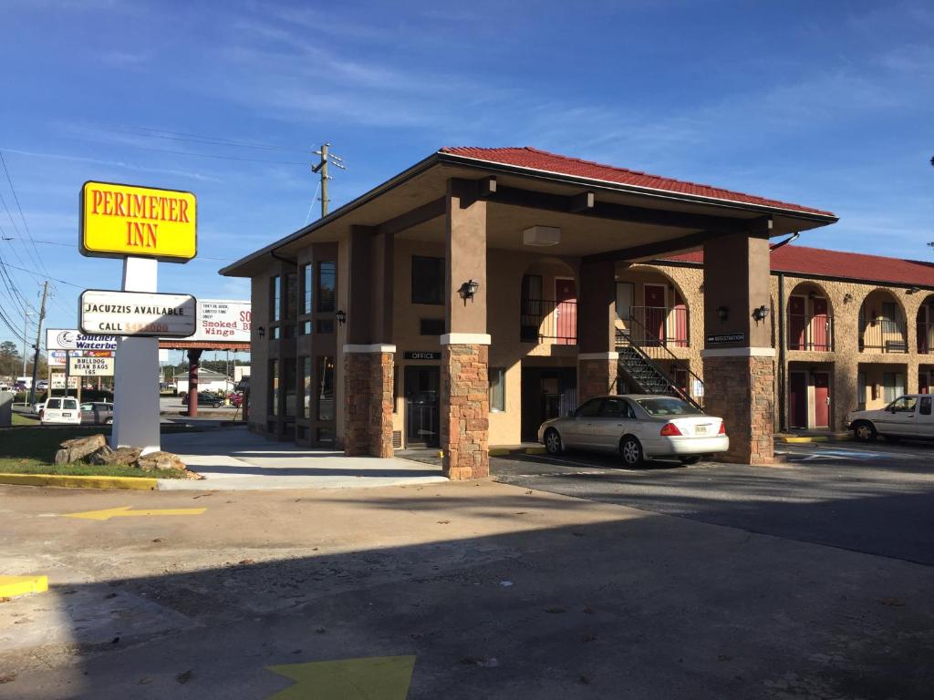 a building with a sign in front of a parking lot at Perimeter Inn - Athens in Athens