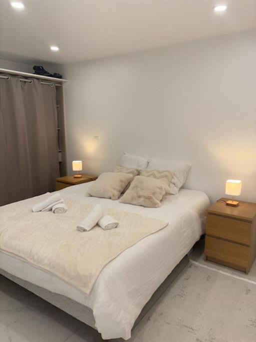 une chambre avec un grand lit blanc avec deux lampes dans l'établissement Le petit moret, à Joinville-le-Pont