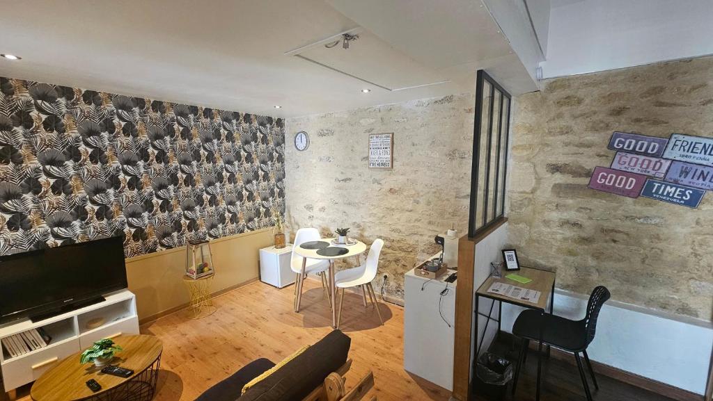 un salon avec une table et des chaises et une cuisine dans l'établissement Une nuit dans le Vexin, à Cléry-en-Vexin