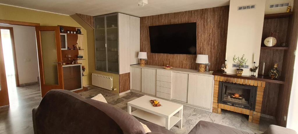 sala de estar con TV y chimenea en Can Tete, en Malgrat de Mar