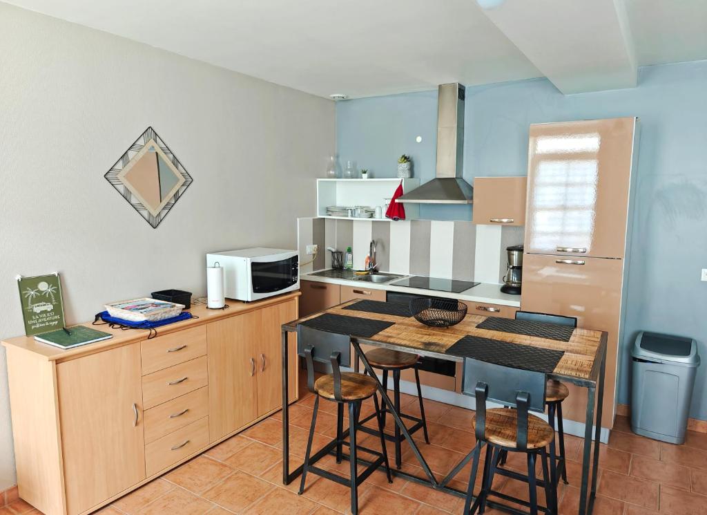 eine Küche mit einem Tisch und einigen Stühlen in der Unterkunft Maison de plain-pied avec un grand jardin in Malicorne-sur-Sarthe