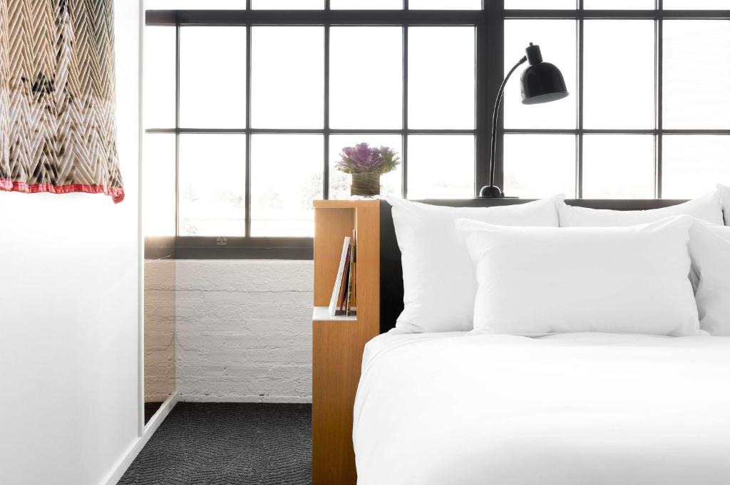 a bedroom with a white bed with white pillows at Fordson Hotel, in the Unbound Collection by Hyatt in Oklahoma City