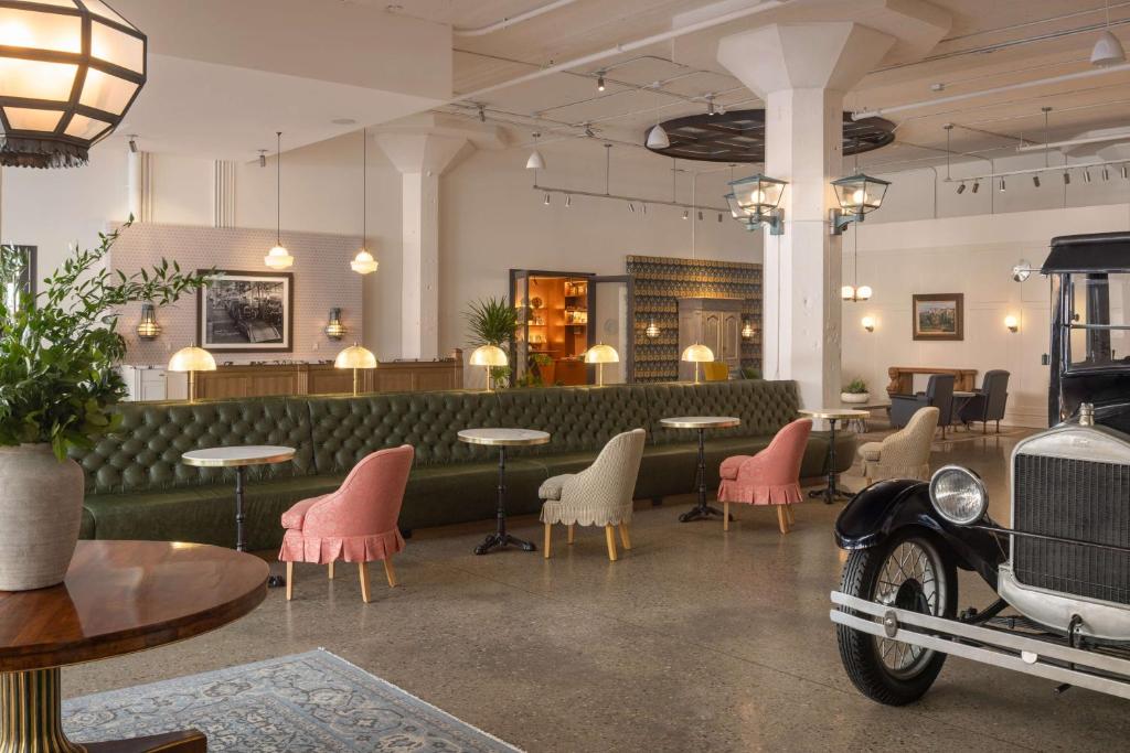 an old car parked in a restaurant with tables and chairs at Fordson Hotel, in the Unbound Collection by Hyatt in Oklahoma City
