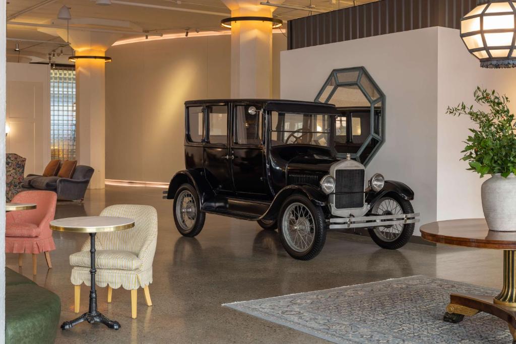 an old black car parked in a room with a mirror at Fordson Hotel, in the Unbound Collection by Hyatt in Oklahoma City