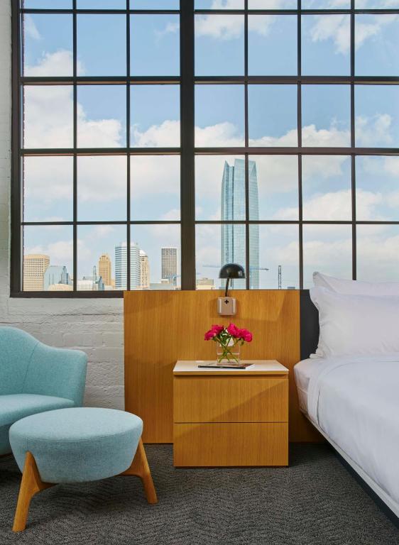 a bedroom with a bed and a chair and a table at Fordson Hotel, in the Unbound Collection by Hyatt in Oklahoma City